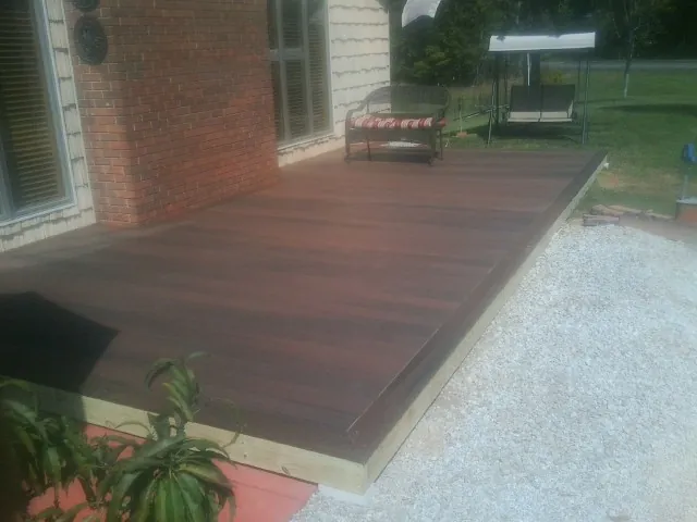 Freshly stained wood deck built against a brick home in Dover